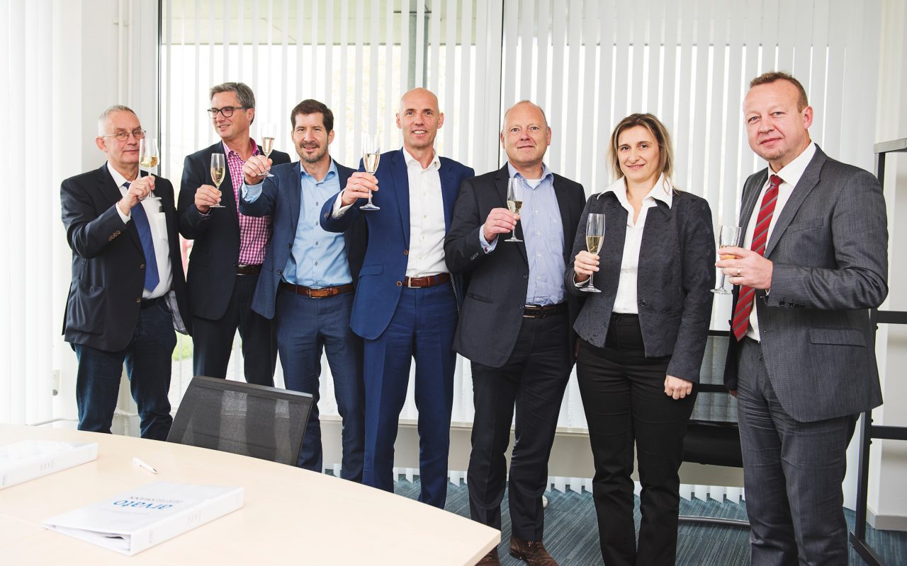 Arvato Systems_Gesundheitswesen_Group of people toasting the contract Arvato Systems_Gesundheitswesen_Group of people toasting the contract